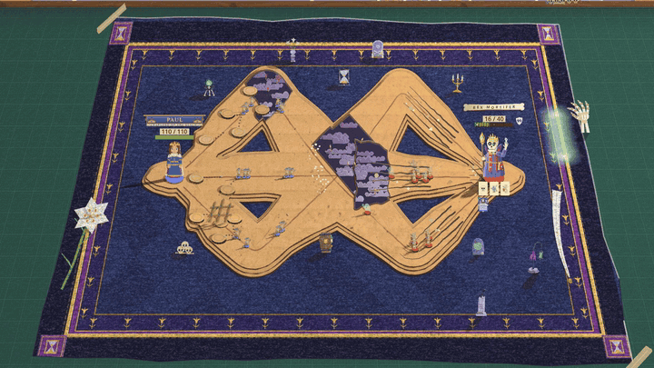 A wide view of a dark blue velvet mat with a gold-trimmed border and a cardboard road, on a green desk. A giant skeletal hand grips the right edge of the mat. A pale green glow runs along the border in both directions, and small gravestones, a cross and an open grave pop up along the border as it passes. On the desk off the left side of the mat, a small white mausoleum unfolds like a pop-up book page and its doors swing open on a light inside