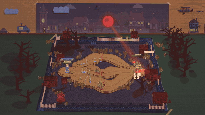 A wide view of Wally's village mat at night, a dark blue knitted throw with a cardboard road, red-lit cottages and black bare trees on the desk, under a painted village with a big red moon. Round the border of the throw, a fence of pale pink fangs stands in a red gum along the far edge and down the sides, with taller curved fangs at the corners. The near side is left open in the middle