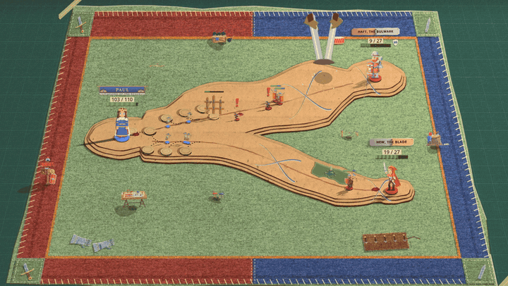 A green felt blanket with a red and blue border and a forked cardboard road. A row of red tents with shields pops up along the far edge next to a red drum, small blue tents pop up scattered across the near side, and then red and blue paper arrows rain down and stick into the mat and the desk all around the blanket