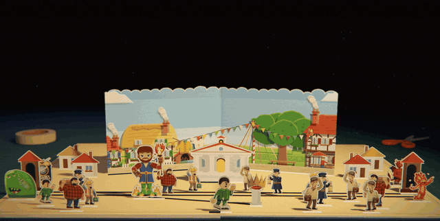 A busy pop-up town square with the warlord among the townsfolk. The page turns over and the next one stands up: strip fields, a windmill and a red-roofed village, with a paper sun rising over the back wall