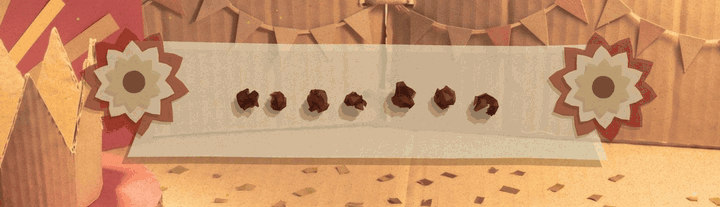The top of the end-of-run page. A cream strip lands with a paper rosette at each end, the word VICTORY forms out of scraps of card, crimson ribbon ends unfold behind the strip, two tails drop under each rosette with paper confetti, and a fan of gold card rays opens and turns behind it